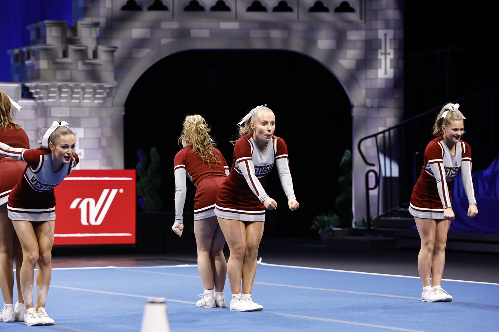 Westosha Central cheer team performing on the blue competition mat